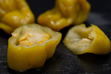 Pickled Golden Greek Peppers, Pepperoncini or Friggitelli (sweet Italian chili pepper) on natural stone background. Capsicum annuum.の写真素材