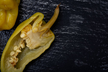 Pickled Golden Greek Peppers, Pepperoncini or Friggitelli (sweet Italian chili pepper) on natural stone background. Capsicum annuum.の写真素材