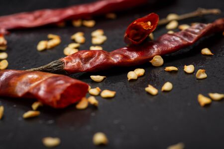 Dried Mexican Red Chile De Arbol Pepper on black natural stone background. Capsicum annuum.