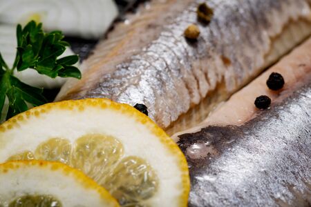 Salted Deboned Herring Fillets garnished with Yellow Onion, Lemon, Fresh Parsley and Peppercorns....