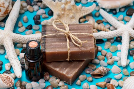 Handmade Frankincense & Myrrh Goat's Milk Bar Soap and Frankincense oil decorated with Pebbles, Sea Stars and Sea Shells on blue background.の写真素材
