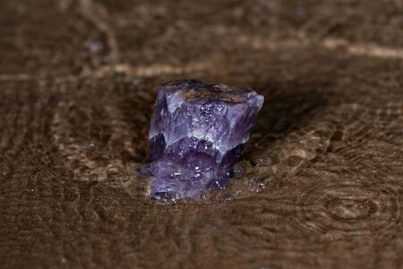 High grade rough natural Purple Auralite 23 Amethyst point from Canada on wet sand  in front of the lake at sunrise.の写真素材