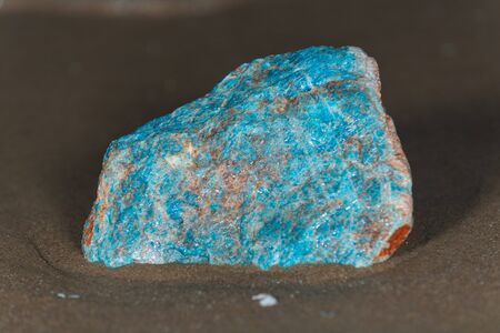 High grade rough natural Blue Apatite Specimen from Madagascar on wet sand  in front of the lake at sunrise.の写真素材