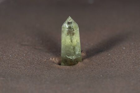 Polished CITRINE single point on wet sand  in front of the lake at sunrise.の写真素材