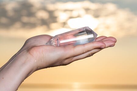 Vogel Style Double Terminated Wand in woman's hand at sunrise in front of the lake.の写真素材