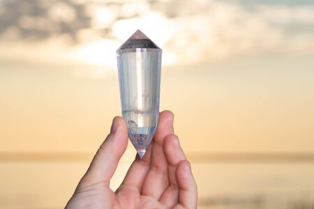 Vogel Style Double Terminated Wand in woman's hand at sunrise in front of the lake.の写真素材