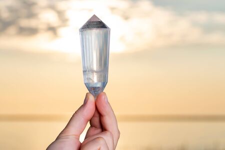 Vogel Style Double Terminated Wand in woman's hand at sunrise in front of the lake.の写真素材