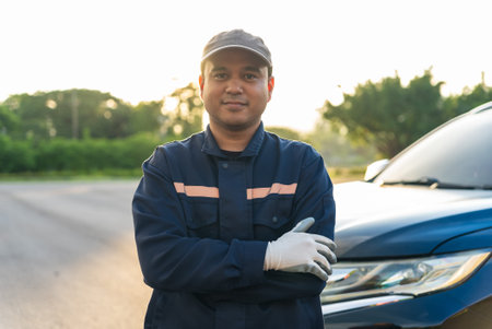 Asian automobile mechanic repairman wearing uniform and protection glove standing with arm crosses and looking at camera After repairing the car, car service and maintenance, Repaiの写真素材