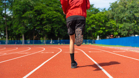 Close up Young Asian men are exercising with outdoor running with a running track background in the...