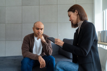 Asian man consulting with asian woman psychologist at mental health clinic. psychologist taking...