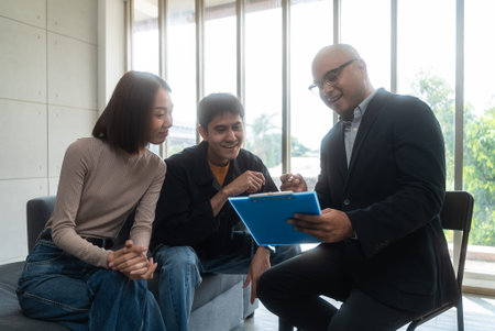 Happy asian couple is planning to sign up for a joint insurance plan covering health, life and...