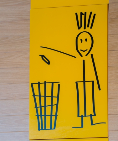 trash bin sign on the wall, yellow backgroundの写真素材