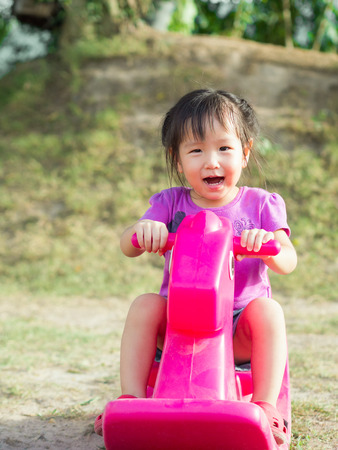 little asain girl sit on the rocking horseの写真素材