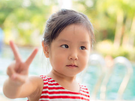 Portrait of an asian cute little girl, victory fingersの写真素材