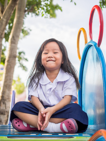 Happy kid, asian baby child in school uniform playing on playgroundの写真素材