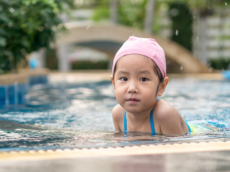 Asian kid is playing in the poolの写真素材