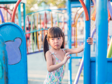 Happy kid, asian baby child playing on playground, sunset lightの写真素材