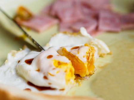 Close-up of fried egg ,  knife cuttingの写真素材
