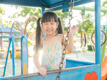 asian baby child playing on playground, in sunset light