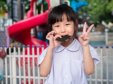 Happy Asian child eating delicious nori seaweedの写真素材