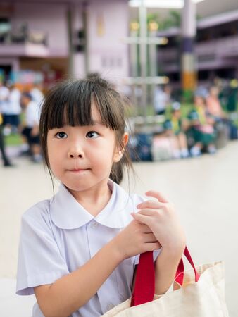Happy kid, asian baby child girl wait her brother and mother at schoolの写真素材