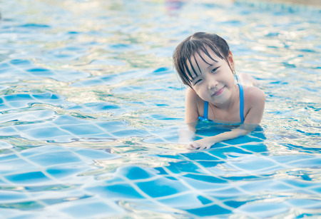 Asian girl is playing in the pool, laying downの写真素材