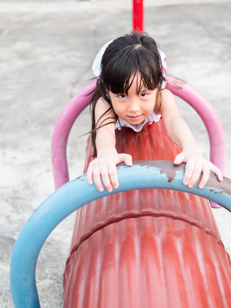 Happy asian baby child playing on playgroundの写真素材