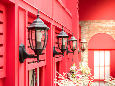 vintage style outside lamp hanging on the red wall backgroundの写真素材