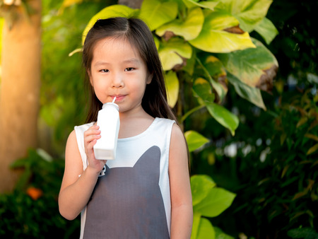 portrait of Asian adorable little girl hold bottle of milkの写真素材