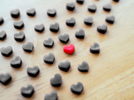 heart shape made from candle on wooden table, selective focus, one redの写真素材