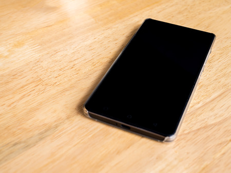office wooden table with black cellphoneの写真素材