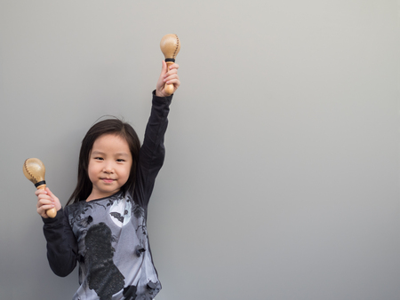 Little asian child play the maracas, gray backgroundの写真素材