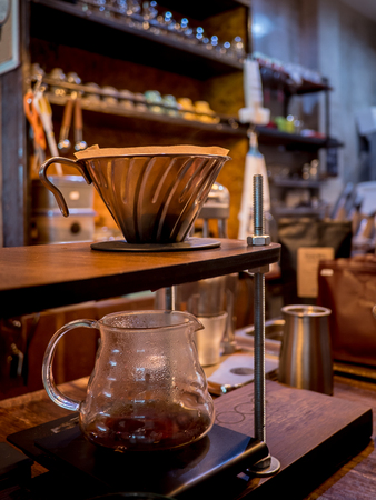 Hand drip coffee. Barista pouring water from silver teapotの写真素材