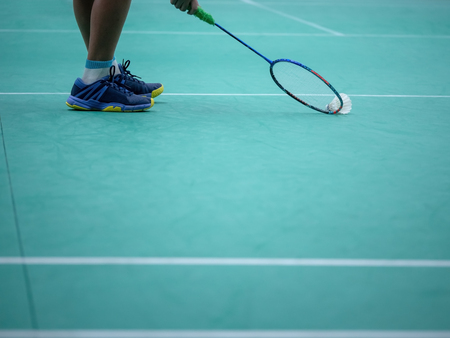 Indoor badminton court with the player leg , shuttle cock and the racquet, selective focusの写真素材