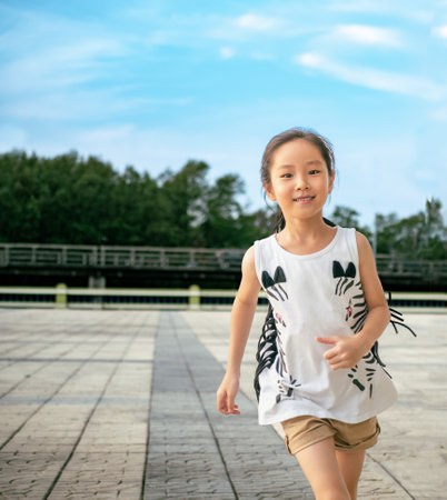 Asian child girl running out door with smileの写真素材