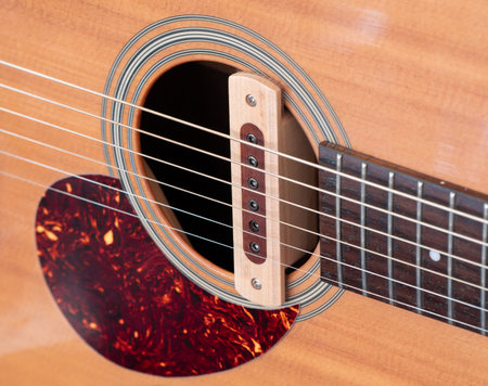 cloise up shot of acoustic guitar sound hole pickup type . made by wood, selective focus