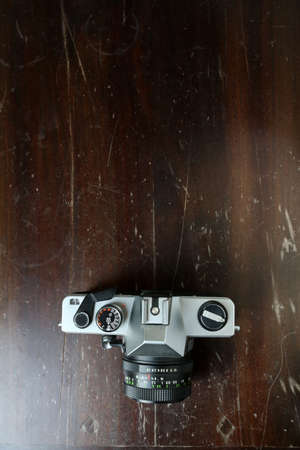 Vintage photo camera on a brown wooden surface