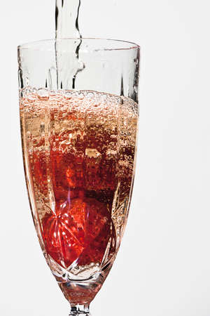 Champagne poured over strawberriesの写真素材