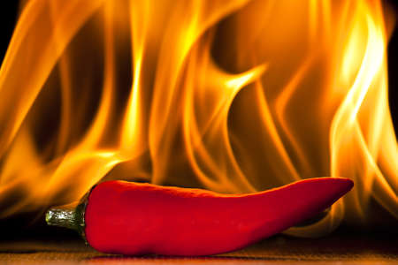 A chilli pepper against a flaming backgroundの写真素材
