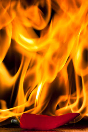 A chilli pepper against a flaming backgroundの写真素材