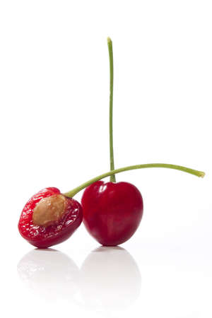 Whole and sliced cherry isolated with reflectionの写真素材