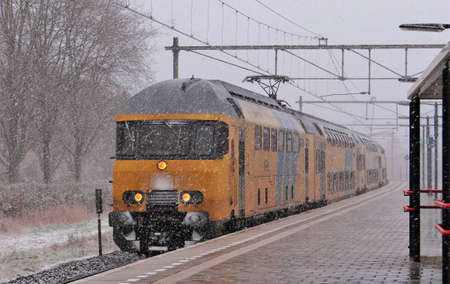 Harderwijk / Netherlands - February 8 2013: A Dutch NS train in a snow blizzard during the winter at the railway station of Harderwijkのeditorial素材