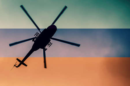 Silhouette of a military helicopter against the background of the flag of Russia.の写真素材