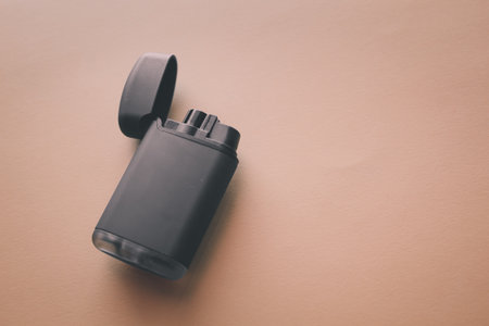Black lighter on beige background. Top view. Copy space.の写真素材