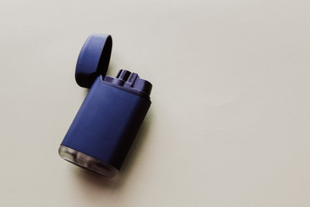 Blue lighter on a beige background. Top view with copy space