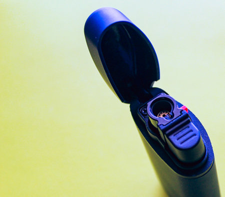 Close-up of a black portable device on a yellow background.の写真素材