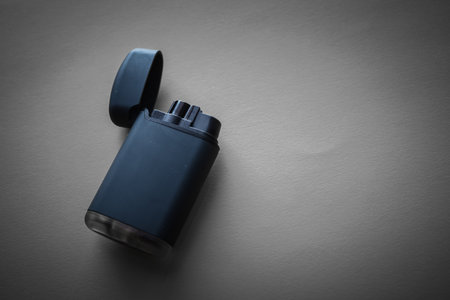 Black lighter on a black background. Shallow depth of field. Toned.の写真素材
