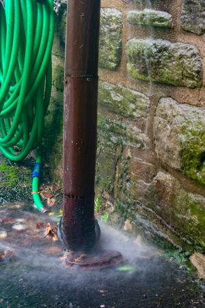 A Long Exposure of Water Flowing Into a Drain During a Violent Rain Storm