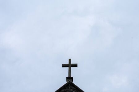 A Cross on the Roof of a Convent on a Cloudy Sky