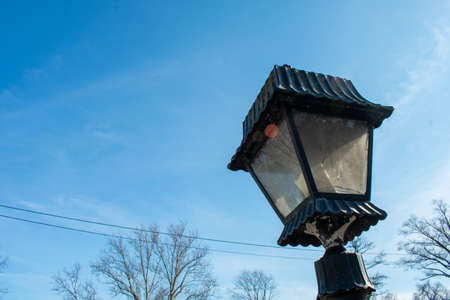 An Old-Fashioned Black Metal Lamp Post on a Clear Blue Skyの写真素材